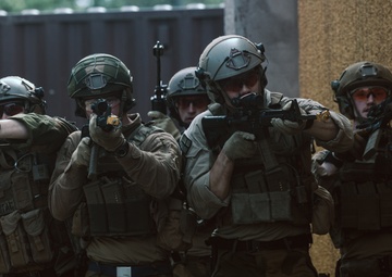 U.S. Marines run through the Outdoor Infantry Immersion Trainer with foreign allied Nations