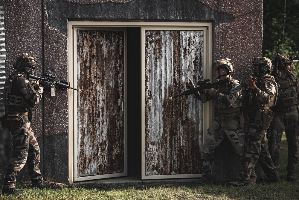 U.S. Marines run through the Outdoor Infantry Immersion Trainer with foreign allied Nations