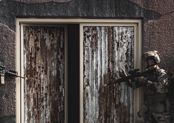 U.S. Marines run through the Outdoor Infantry Immersion Trainer with foreign allied Nations