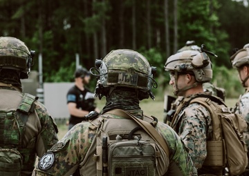 U.S. Marines run through the Outdoor Infantry Immersion Trainer with foreign allied Nations