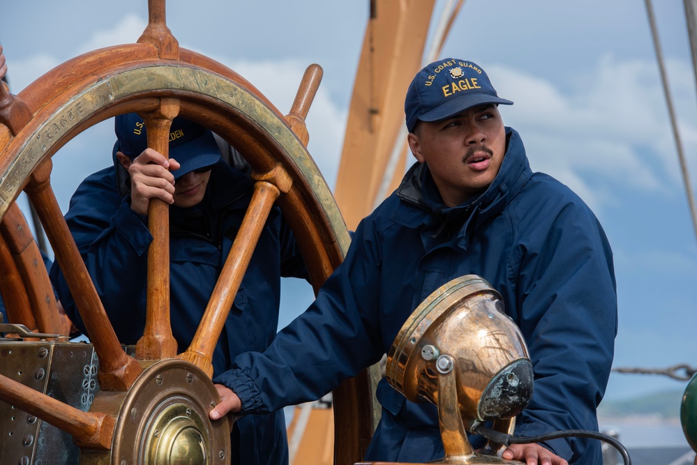 USCGC Eagle crew member helms cutter