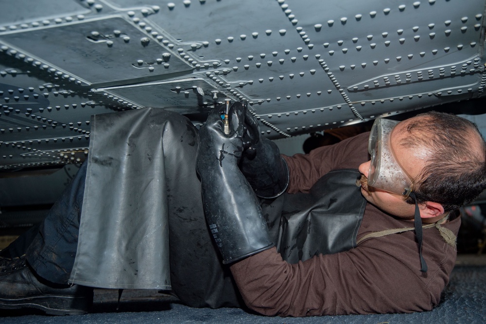 USS Ronald Reagan (CVN 76) Sailors work in the hangar bay