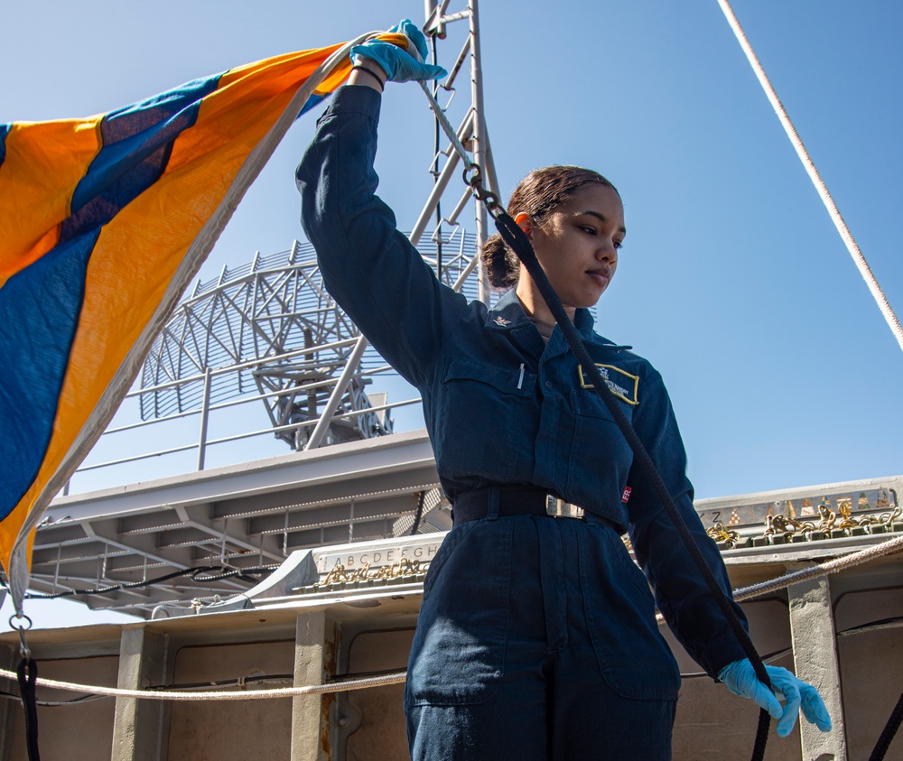 Sailor Prepares To Raise Signal Flag