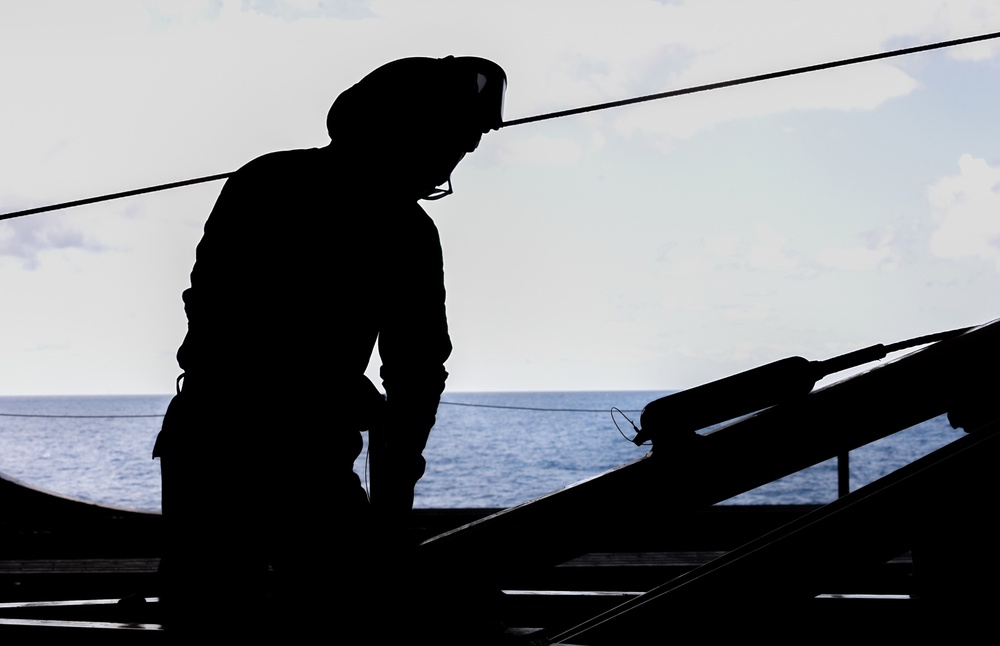 USS Ronald Reagan (CVN 76) Sailors perform maintenance on utility crane