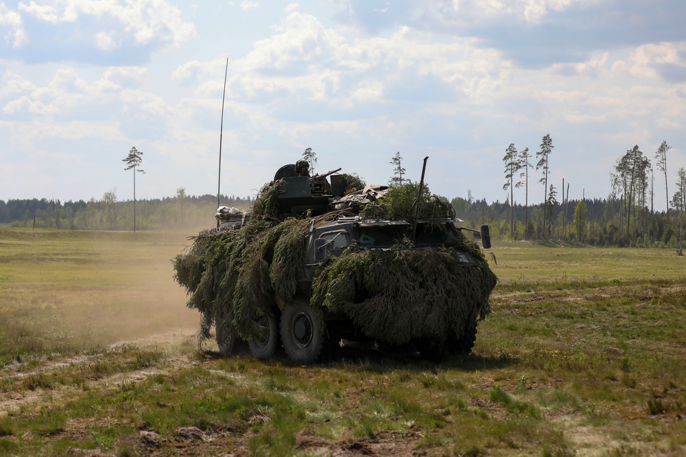 Estonian soldiers drive an APC at Spring Storm 23