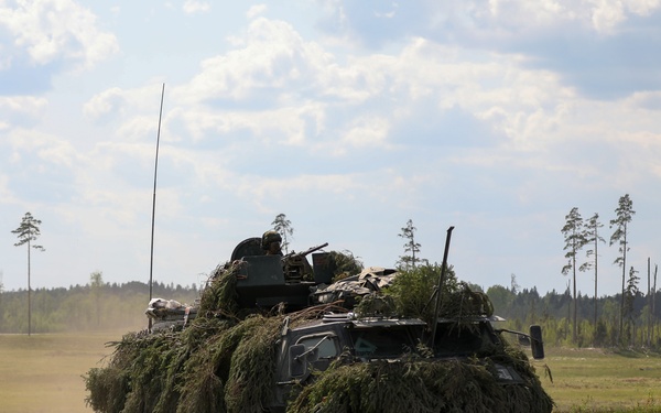 Estonian soldiers drive an APC at Spring Storm 23