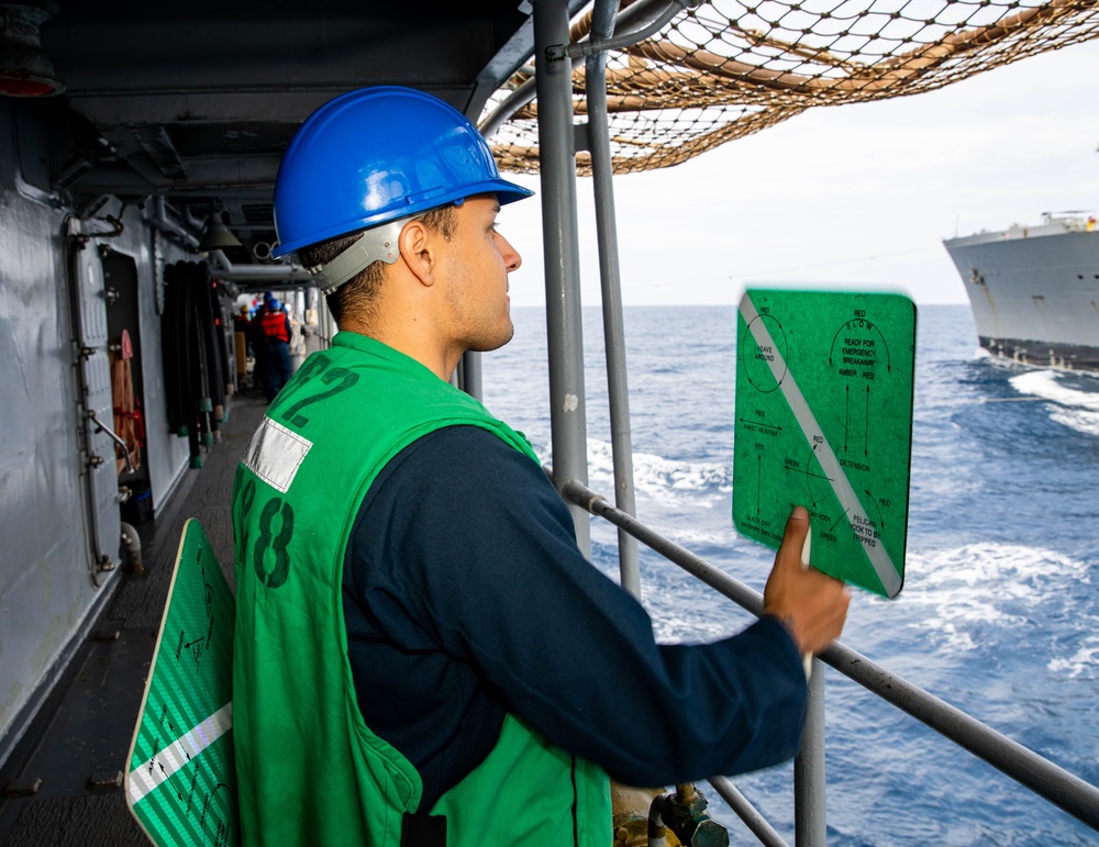 USS Robert Smalls (CG 62) Sailor Signals USNS Tippecanoe (T-AO-199) During RAS