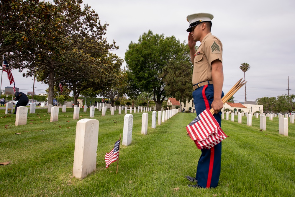 Sailors and Marine place flag at service members graves