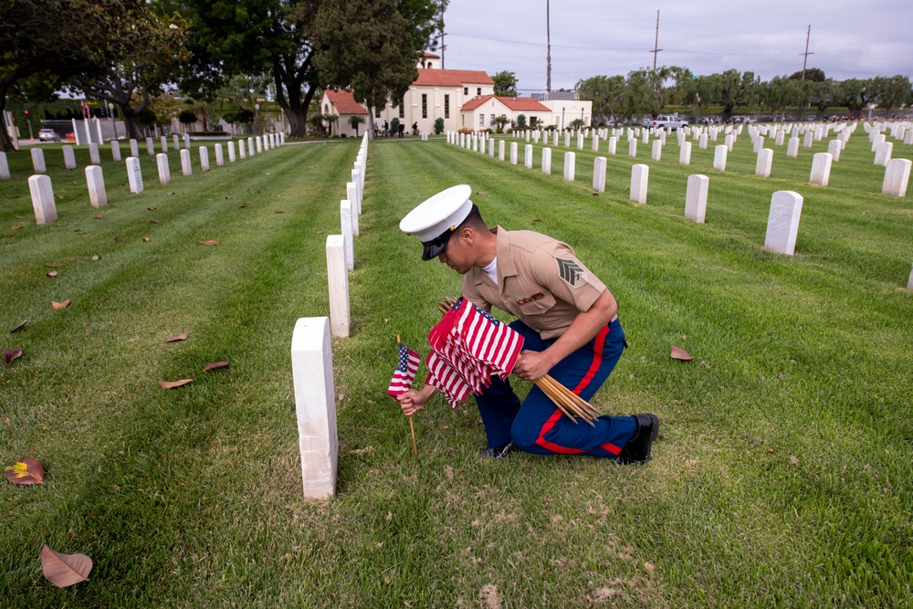 Sailors and Marine place flag at service members graves