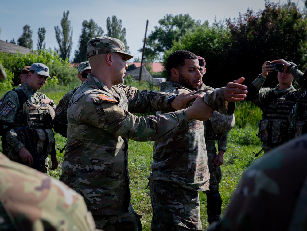 Soldiers from the 508th Military Police Company demonstrate detaining procedures to Albanian and Bulgarian servicemen during DEFENDER 23