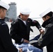 USS Harpers Ferry (LSD 49) sailors fold the ensign as the ship gets underway