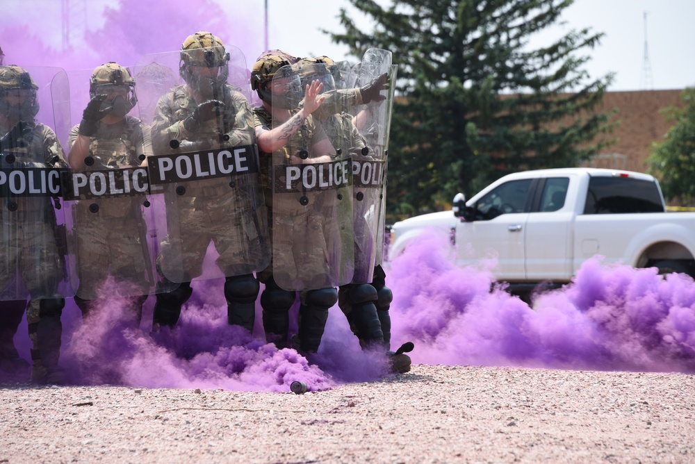 Security Forces Airmen walk through smoke