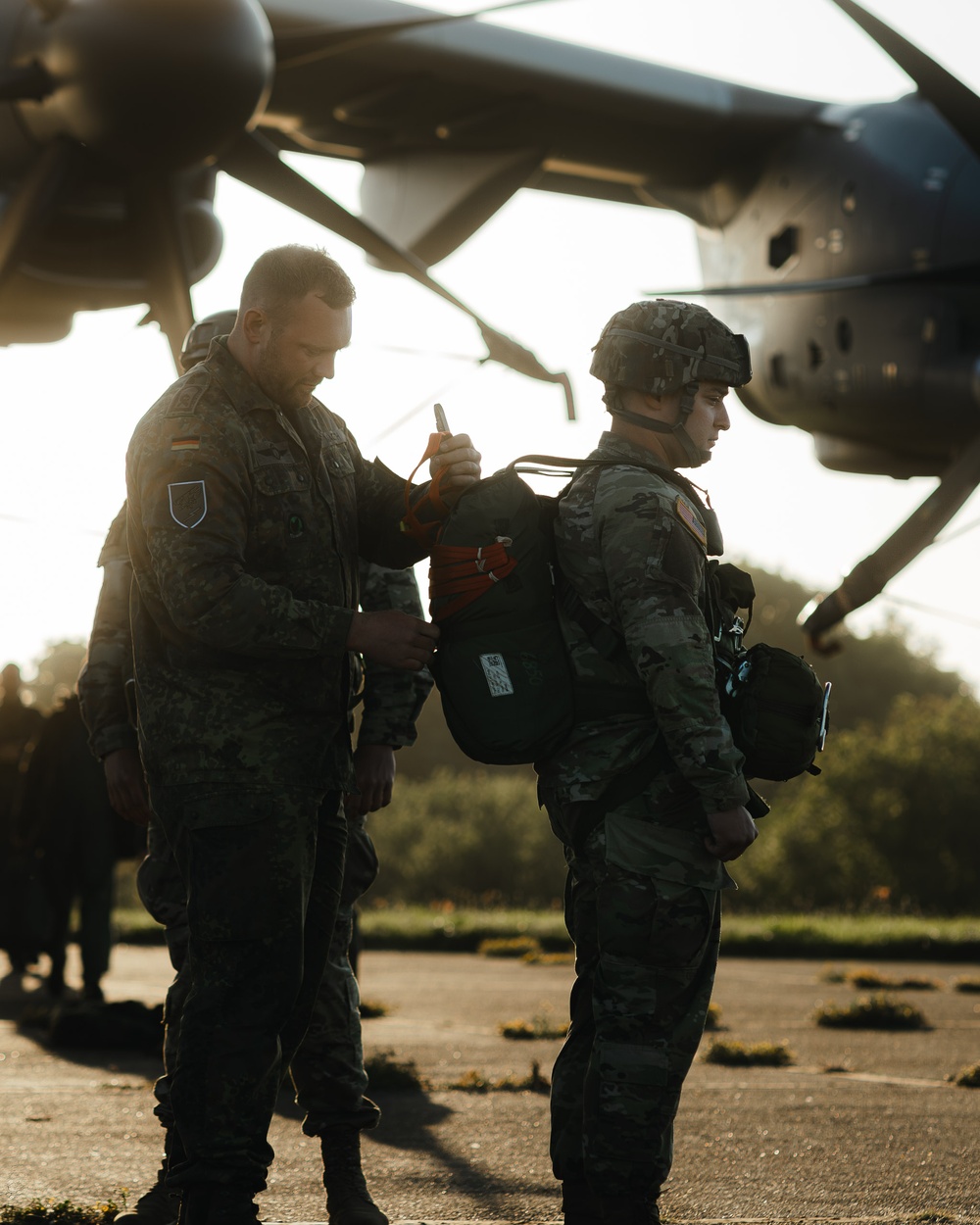 A German Paratrooper Inspects U.S. Paratrooper's T-10 Parachute System