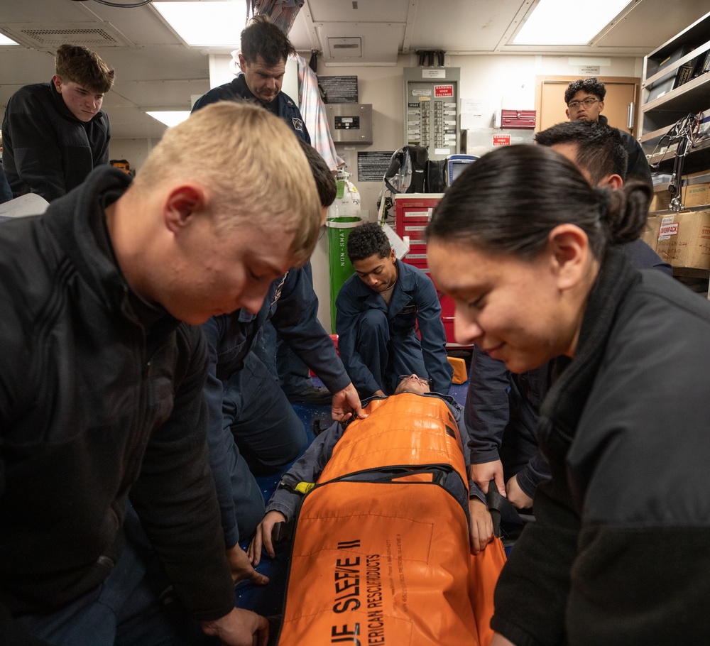 USS Harpers Ferry (LSD 49) sailors prepare to lift their shipmate in stretcher bearer training