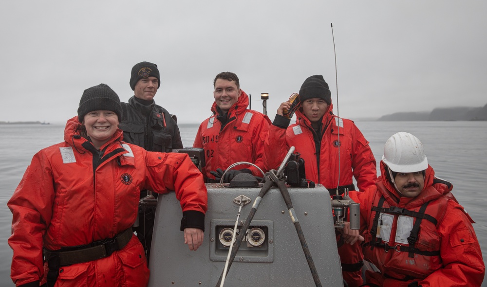 USS Harpers Ferry (LSD 49) sailors follow ship into port in Kodiak, Alaska