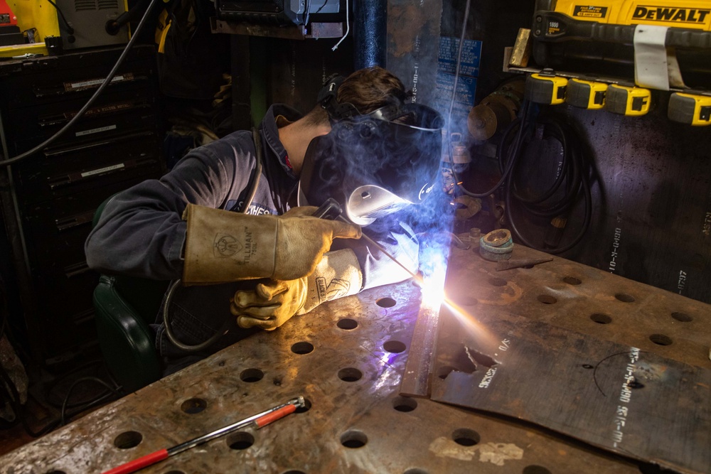 Hull Maintenance Technician 2nd Class Montgomery Scythes Welds Metal Pieces Together