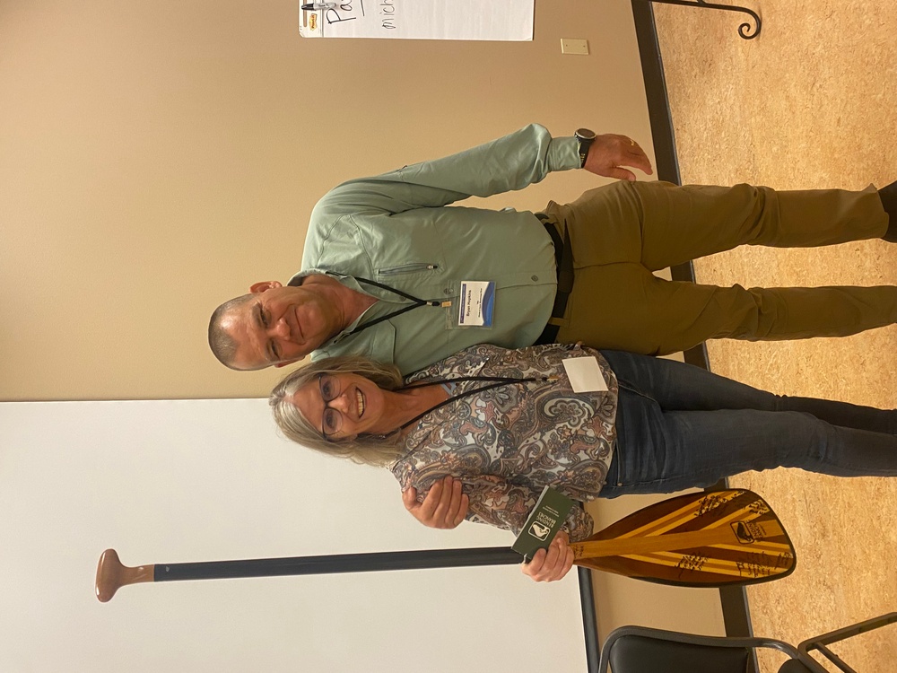 Grethen Benjamin receives paddle for her contributions to the Sustainable Rivers Program.