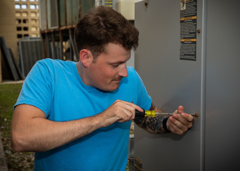 ESl Sailors Assess AC Unit on Anderson AFB