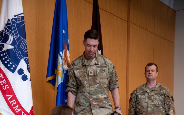 Newly pinned Air Force major accepts his duty with nose bop, paw salute
