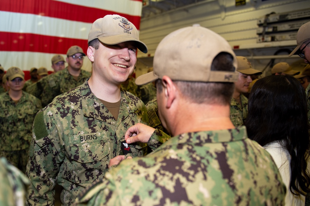 Boxer Promotes 128 Sailors in Ceremony