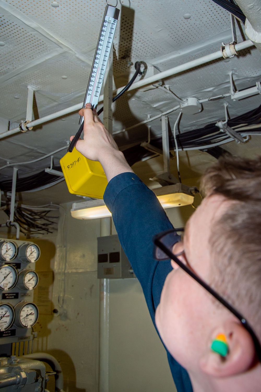 USS Ronald Reagan (CVN 76) Sailor stands steering gear room watch