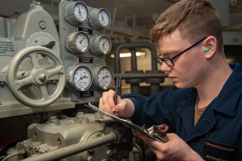 USS Ronald Reagan (CVN 76) Sailor stands steering gear room watch