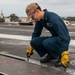 Sailor preforms maintenance the flight deck aboard USS Carl Vinson (CVN 70)
