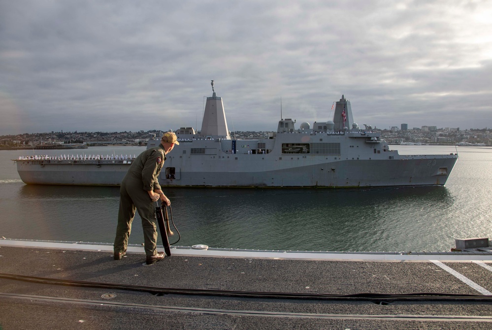 Sailors render honors to USS Anchorage as it returns to home port