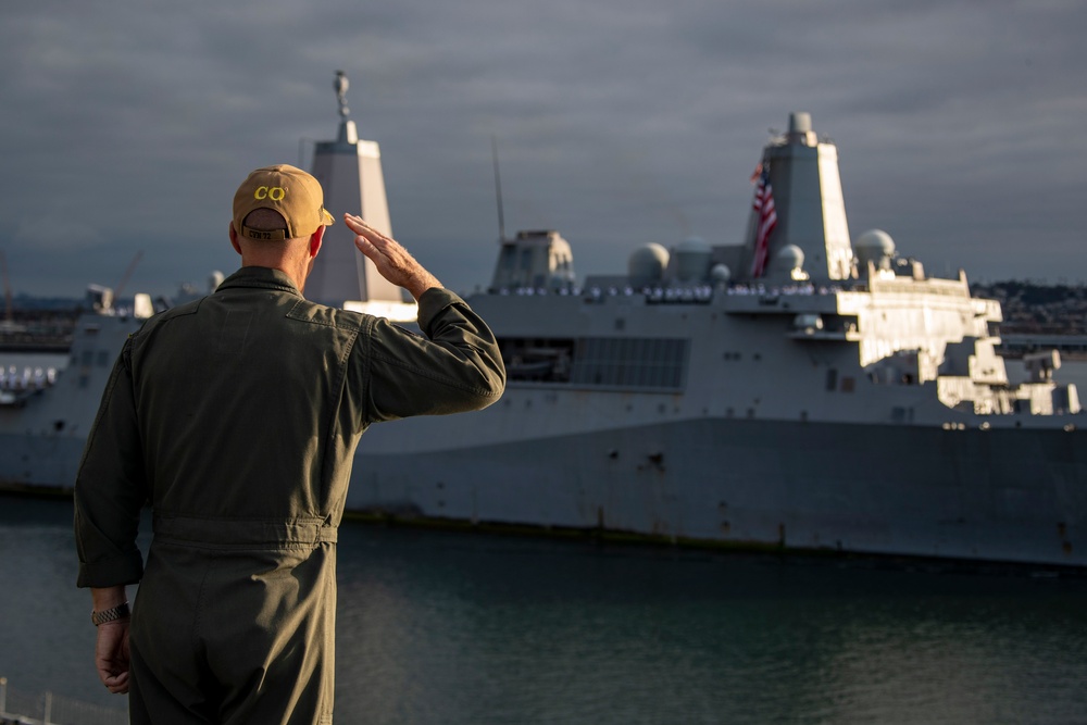 Sailors render honors to USS Anchorage as it returns to home port