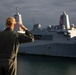 Sailors render honors to USS Anchorage as it returns to home port