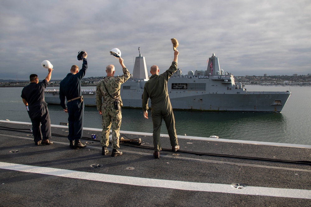 Sailors render honors to USS Anchorage as it returns to home port