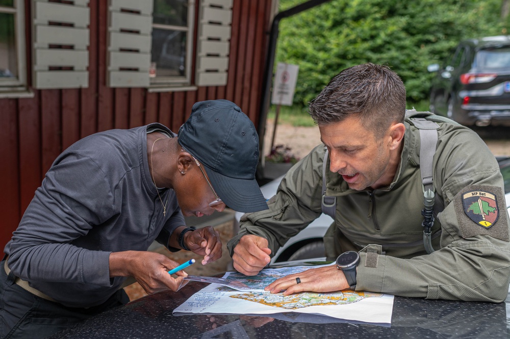 Air Force Reserve Maj. Sterling Broadhead  plans his route with Army Reserve Sgt. Alecia Jones