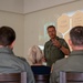 German air force Col. Christian John speaks to a group of local politicians and citizens during exercise Air Defender 2023