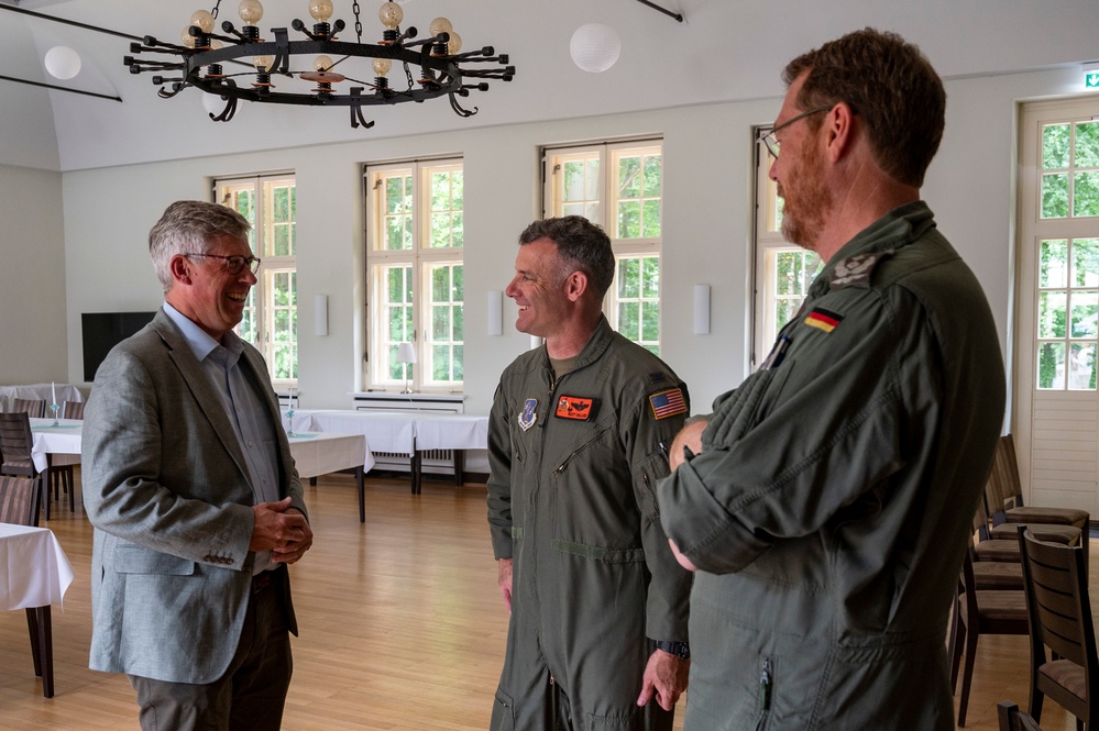 U.S. Air Force Col. Rusty Ballard, Col. Christian John, and Mayor Carsten Piellusch converse at exercise Air Defender 2023