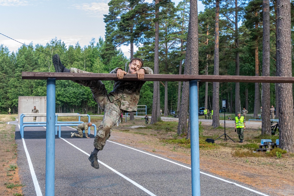 Air Force Reserve Lt. Col. Beau Suder climbs an obstacle