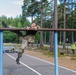 Air Force Reserve Lt. Col. Beau Suder climbs an obstacle