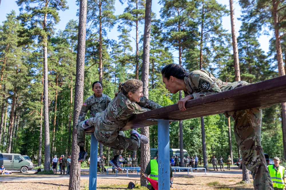 Army Reserve 1st Lt. Jessica Romero, Air Force Reserve Col. Elizabeth Blanchford and Army Reserve Sgt. Christine Won complete an obstacle together