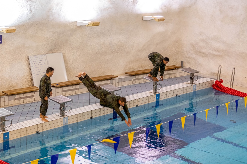 Air Force Reserve Maj. James Fink, Air Force Reserve Col. Ryan “MZ” Montanez and Army Reserve Capt. Kevin Tirado compete in the swim obstacle course