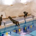 Air Force Reserve Maj. James Fink, Air Force Reserve Col. Ryan “MZ” Montanez and Army Reserve Capt. Kevin Tirado compete in the swim obstacle course