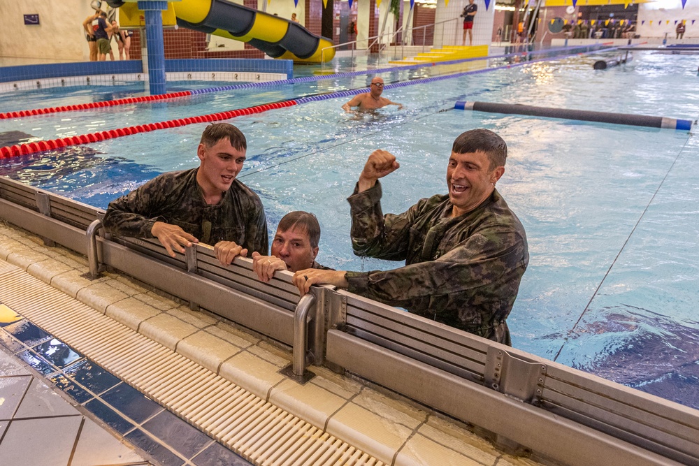 U.S. Air Force Reserve Maj. Sterling Broadhead, Norwegian Lt. Kristopher Smith and Dutch Lt. Erik Lammerts van Bueren complete the swim obstacle course