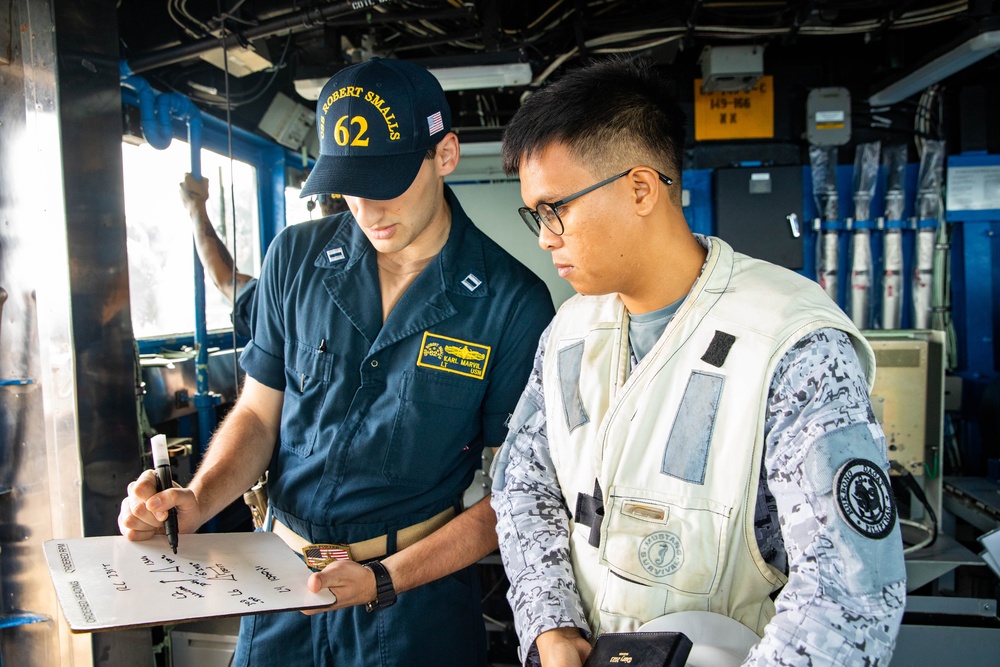 USS Robert Smalls (CG 62) Sailor discusses UNREP with Philippine Navy Sailor