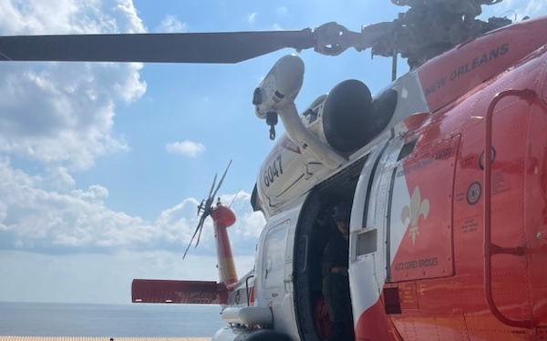 Coast Guard MH-60 Jayhawk helicopter sits on board offshore platform. 