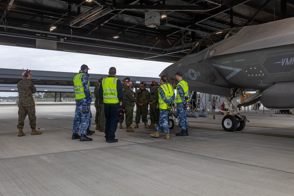 U.S Marines and Australian Airmen load CATM-120 Missiles together