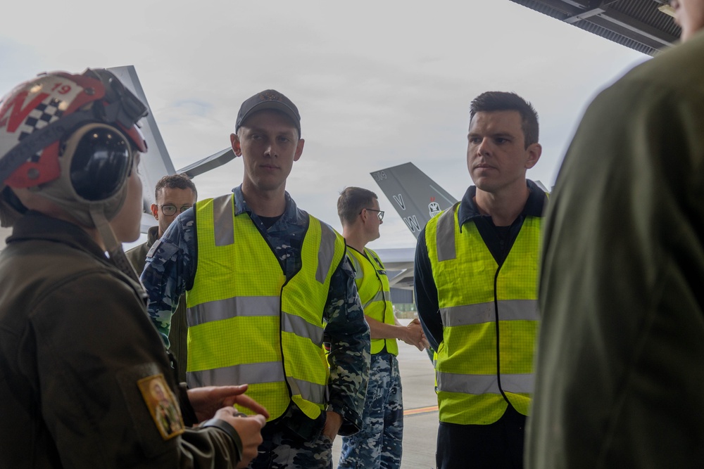 U.S Marines and Australian Airmen load CATM-120 Missiles together