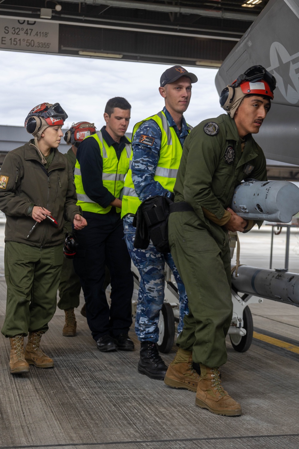 U.S Marines and Australian Airmen load CATM-120 Missiles together