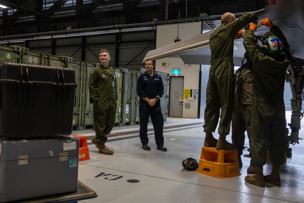 U.S Marines and Australian Airmen load CATM-120 Missiles together