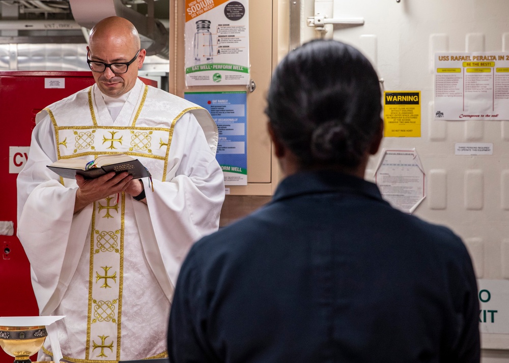 USS Rafael Peralta (DDG 115) holds a catholic service on the mess decks