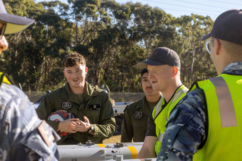 U.S. Marines and Australian Airmen load Missiles on Joint Strike Fighters together  