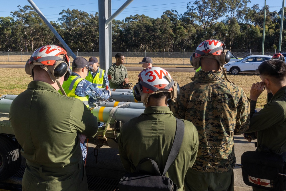 U.S. Marines and Australian Airmen load Missiles on Joint Strike Fighters together  