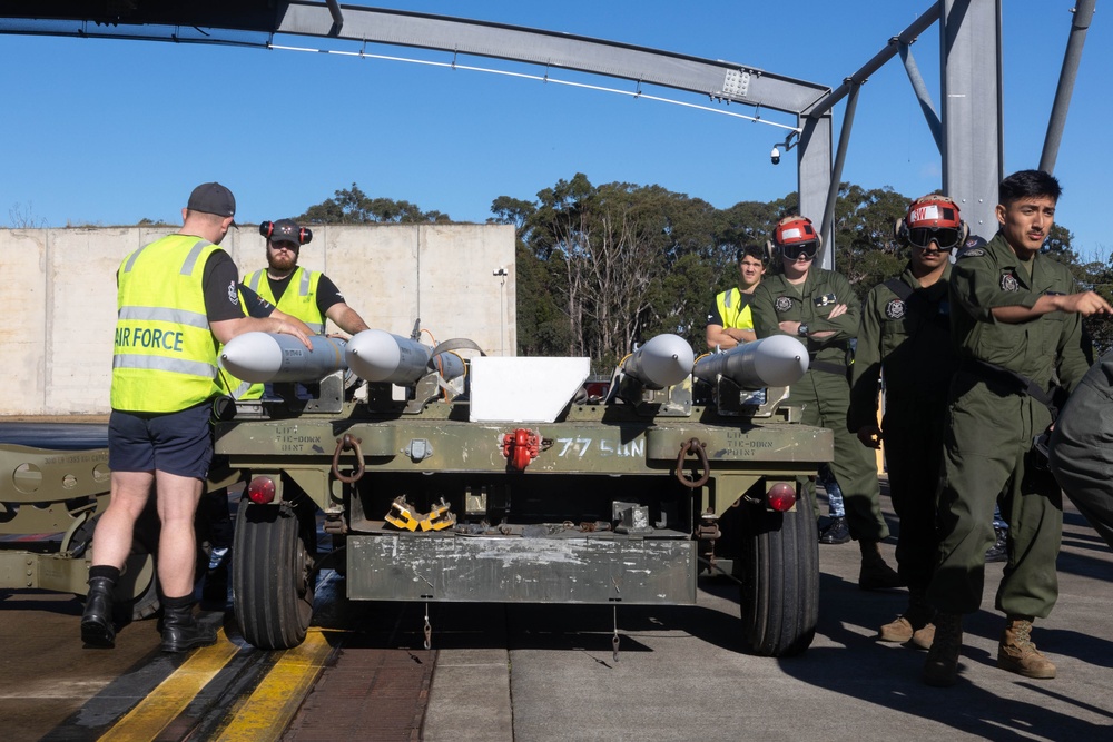 U.S. Marines and Australian Airmen load Missiles on Joint Strike Fighters together  